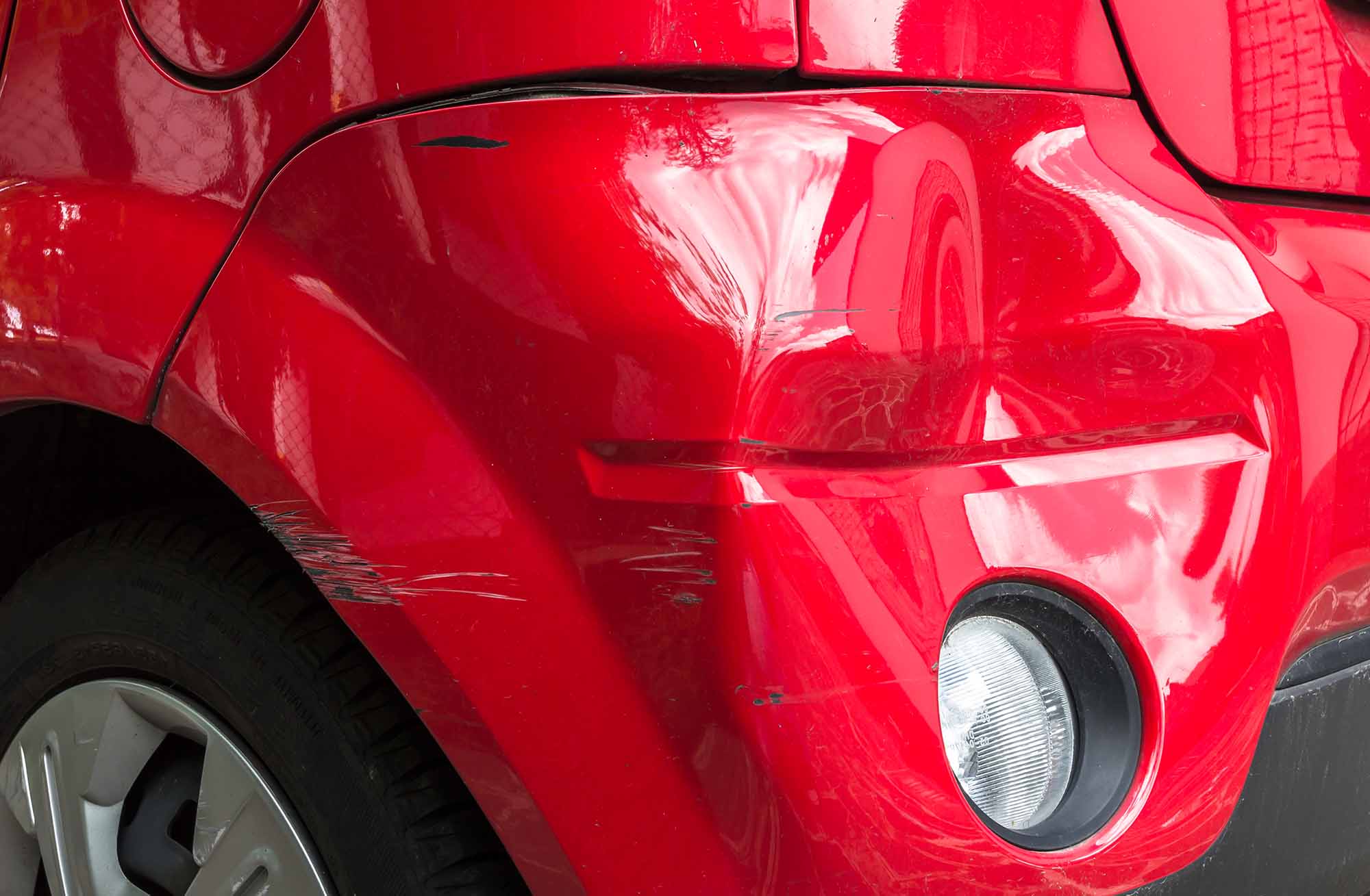 how to fix bumper dent - red car with dented bumper
